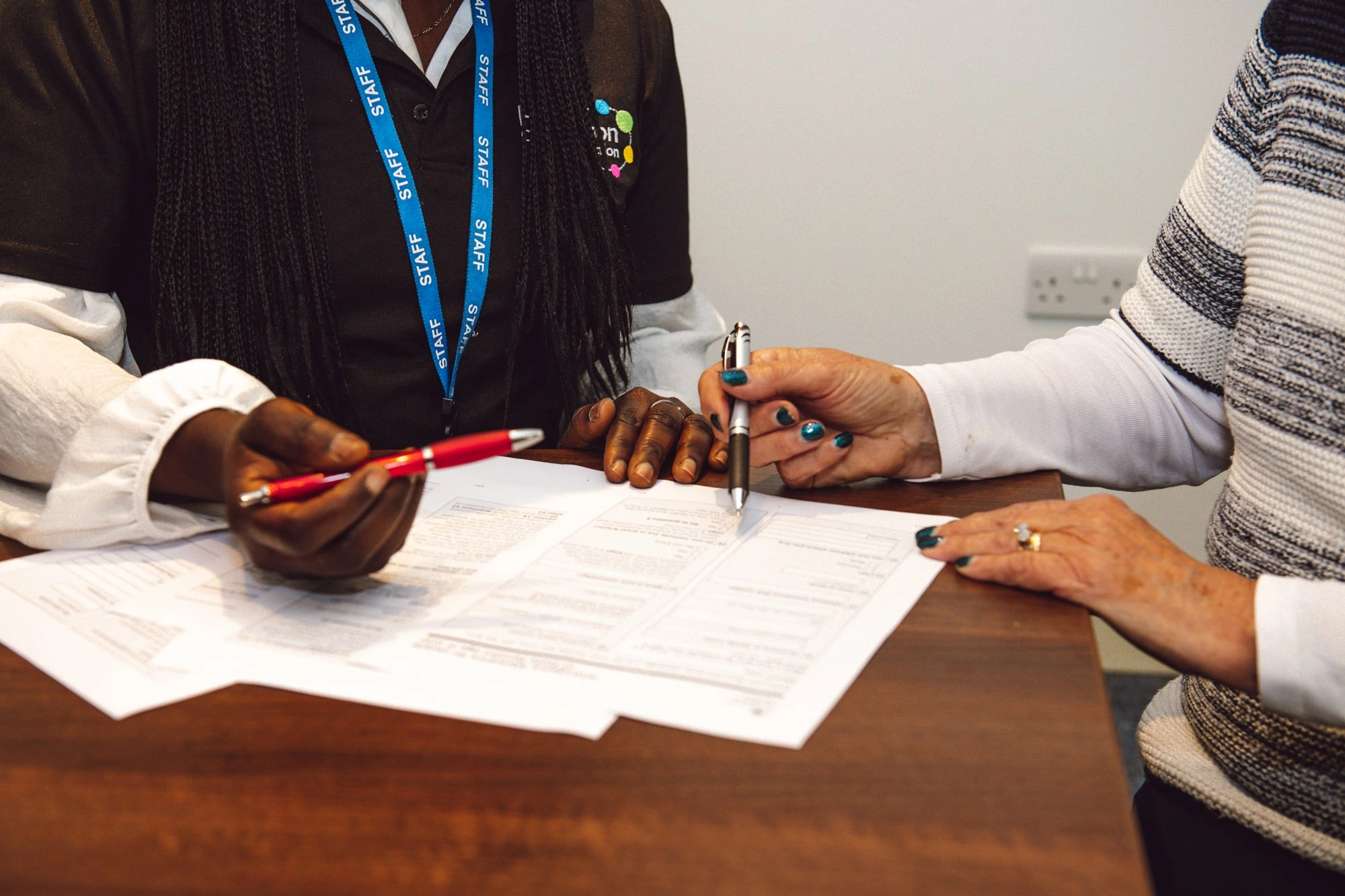 close up of two people looking at a form discussing how to fill it in